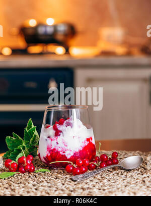 Eis Dessert mit Rote Johannisbeere Marmelade und frischen Beeren. Küche für den Hintergrund. Stockfoto