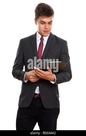 Junge gut aussehender Geschäftsmann stehen beim Lesen über die Zwischenablage Stockfoto