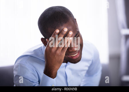 Nahaufnahme einer jungen afrikanischen Mann in Schmerz hielt seinen Kopf Stockfoto
