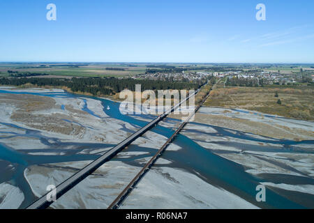 Straße und Schiene Brücken über Rakaia Fluss und Rakaia Township, Mid Canterbury, Südinsel, Neuseeland - Luftbild Stockfoto