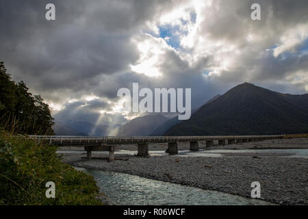 Eine lange Brücke kreuzen über eine geflochtene Fluss in einem Alpental, Canterbury, Neuseeland Stockfoto