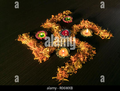 Ein Blick von Oben auf die Diya gehalten auf Blumen Stockfoto