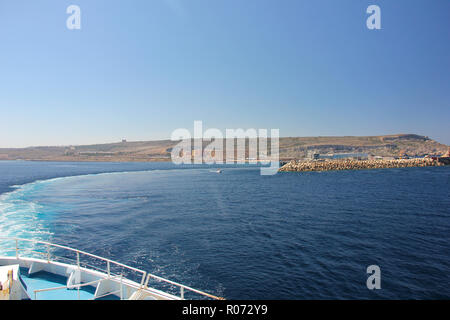 Azure Bogen auf blauem Wasser. Die Fähre fährt vom Ufer in Cirkewwa Ferry Terminal Stockfoto