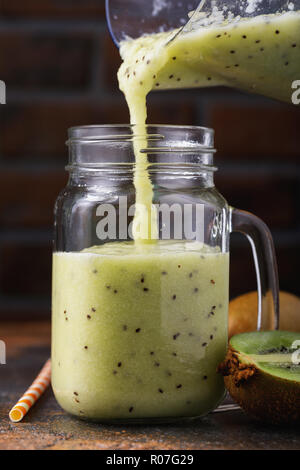 Prozess der Gießen frisch zubereitete Smoothies von Kiwi in einem Glas Stockfoto