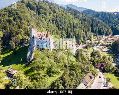 Schloss Bran, auf einem Hügel mit hohen Türmen, Mauern, roten Ziegeldächern, von Kleie Stadt, der Walachei, Siebenbürgen, Rumänien umgeben. Als Draculas Schloss bekannt. Stockfoto