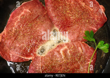 Red Steak gebraten in der Pfanne. Kochen des Fleisches, Ansicht von oben Stockfoto