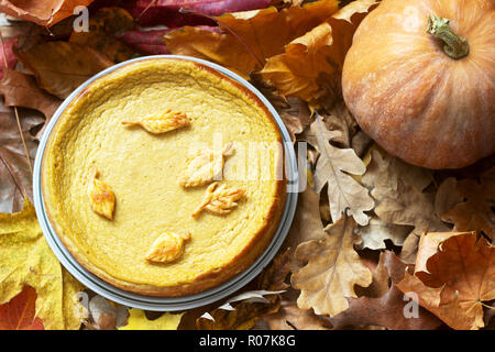 Traditionelle amerikanische Kürbis hausgemachte Kuchen, mit Cookies auf dem Hintergrund der Kürbisse und Blätter im Herbst eingerichtet. Stockfoto
