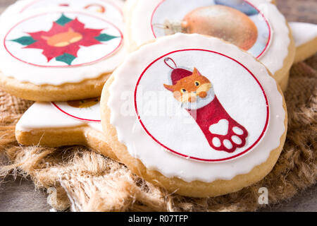 Hausgemachte butter Cookies mit einer gedruckten Weihnachten cat Design auf hölzernen Tisch Stockfoto