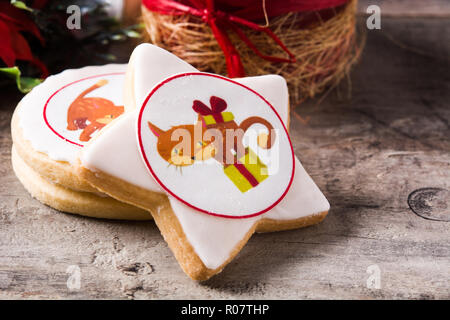 Hausgemachte butter Cookies mit einer gedruckten Weihnachten cat Design auf hölzernen Tisch Stockfoto