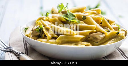 Nudeln mit Huhn Stücke sichern Pilze Parmesan Sauce und Kraut Dekoration. Sichern con pollo - Italienisch oder medierranean Küche. Stockfoto