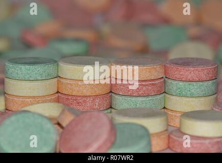 Ein buntes Bild mit vier Stapeln von gemeinsamen Magensäure Pillen mit vielen anderen verstreut Pillen in den Vordergrund und Hintergrund. Stockfoto