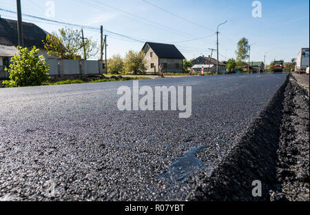 Frisch schwarz Bitumen Asphalt mit einer hohen Flanke auf den Kies für den Aufbau gelegt. Zur Festlegung einer neuen Asphalt auf den Straßen. Bau der Straße. Stockfoto