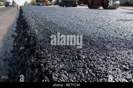 Frisch schwarz Bitumen Asphalt mit einer hohen Flanke auf den Kies für den Aufbau gelegt. Zur Festlegung einer neuen Asphalt auf den Straßen. Bau der Straße. Stockfoto