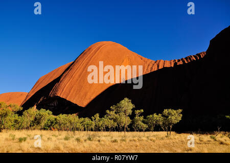 OUTBACK, AUSTRALIEN - 30. APRIL 2009: rot-orange Uluru, Ayers Rock nach Sonnenaufgang gegen den tiefblauen Himmel - eine der UMESCO Welterbe Stockfoto