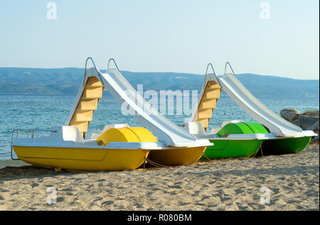 Tretboote mit Wasserrutschen am Strand. Stockfoto