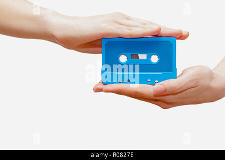 Hände, die blaue Kassette in weißem Hintergrund Stockfoto