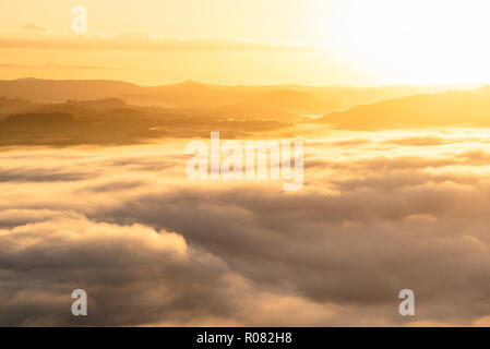 Erste Sonnenstrahlen des Tages den Wolken über der Elbe Santstone Nationalpark im goldenen Licht schalten, im östlichen Niedersachsen, Deutschland Stockfoto