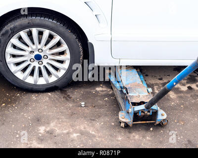 Hydraulischen Wagenheber hebt ein Fahrzeug im Freien für saisonale Austausch der Reifen Stockfoto