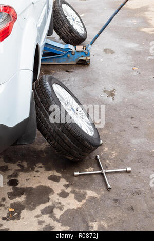 Räder entfernt in der Nähe der angehobenen Fahrzeug im Freien für saisonale Austausch der Reifen Stockfoto