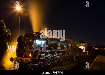 Lange Exposition, Night Shot von hinten beleuchtete, haltbar, UK Dampflokomotive, die Übernahme von Wasser bei SVR-Station in der Dunkelheit. Motor releases Dampf aus Trichter. Stockfoto