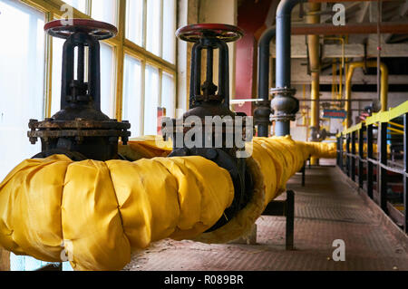 Zwei große schwarze Tor auf der Heizung Rohr isoliert gelb Tuch. Stockfoto