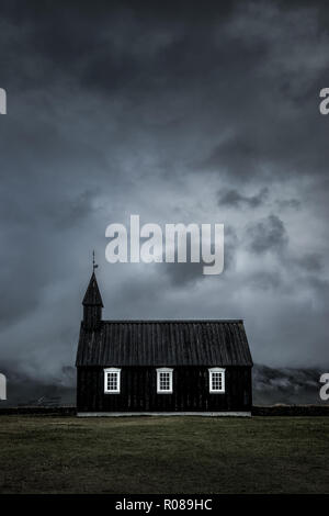 Die Schwarze Kirche in Budir Snaefellsnes Halbinsel mit einer stürmischen bewölkten Himmel in Island Stockfoto