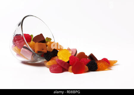 bunte Bonbons in Glasschüssel auf weiß Stockfoto