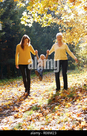 Drei Generationen von Frauen. Großmutter, Tochter und Enkelin wandern im herbstlichen Wald, Tschechische Republik Stockfoto