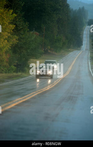 Autos fahren auf Regen nasser Fahrbahn in der Nähe von Flathead Lake, Montana Stockfoto