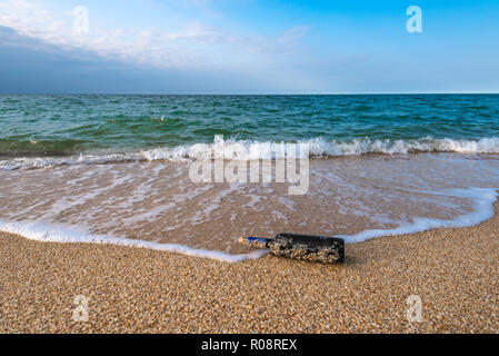 Eine Nachricht in einer Flasche mit korkgeschmack am leeren Strand Stockfoto