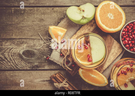 Wein mit Orangen, Granatäpfel, rustikalen Hintergrund Glühwein Stockfoto