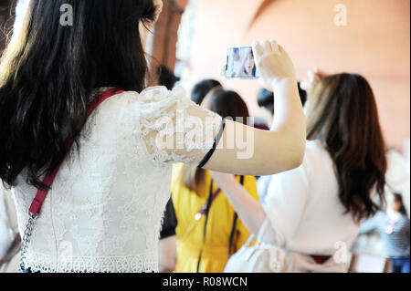 Schöne asiatische Frau unter selfie mit Ihrem Smartphone. Sie warten, um zu sehen, der Mund der Wahrheit (Bocca della Verità). Kirche Santa Maria in Cosmedin Stockfoto