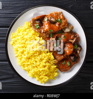 Fricando ist eine katalanische langsam kochen Rindfleisch Eintopf, Wein und Champignons Sauce mit gelber Reis in der Nähe serviert geschmort - bis auf den Teller. top Blick von oben Stockfoto