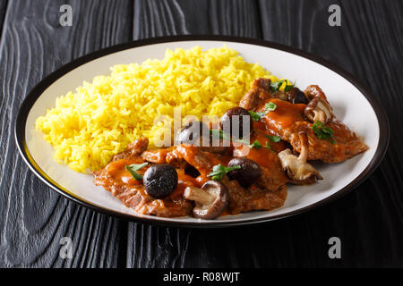 Fricando ist eine katalanische langsam kochen Rindfleisch Eintopf, Wein und Champignons Sauce mit gelber Reis in der Nähe serviert geschmort - bis auf einen Teller. Horizontale Stockfoto