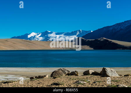 Schneebedeckte Berge, die sich hinter dem tiefblauen Wasser von Tso Moriri, 4,595 m über dem Meeresspiegel in Changtang Bereich befindet. Stockfoto