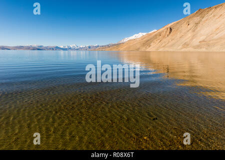 Schneebedeckte Berge, die sich hinter dem tiefblauen Wasser von Tso Moriri, 4,595 m über dem Meeresspiegel in Changtang Bereich befindet. Stockfoto