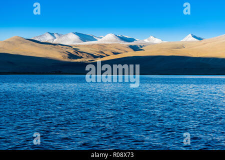 Schneebedeckte Berge, die sich hinter dem tiefblauen Wasser von Tso Moriri, 4,595 m über dem Meeresspiegel in Changtang Bereich befindet. Stockfoto