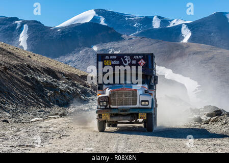 Ein Lkw auf der staubigen Straße fahren bis zum Taglang La (5.325 m), den höchsten Pass auf dem manali-leh Highway, schneebedeckten Berge Stockfoto