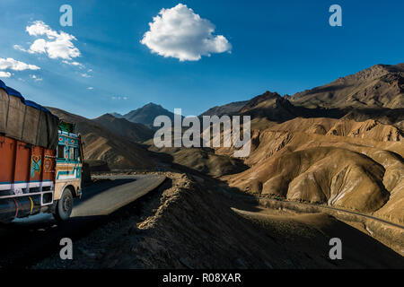 Ein Lkw fahren hinunter nach Lamayuru auf Srinagar-Leh-Highway durch eine karge Landschaft mit blauem Himmel und weißen Wolken, auf einer Höhe von 4.000 entfernt Stockfoto