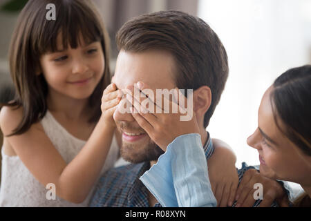 Liebevolle Tochter und Mutter Abdeckung männlichen Augen Stockfoto