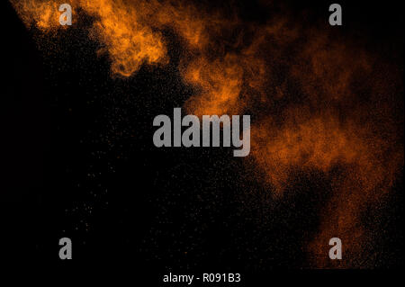 Abstrakte orange Lack Holi. Abstrakte orange Pulver Explosion auf schwarzen Hintergrund. Stockfoto