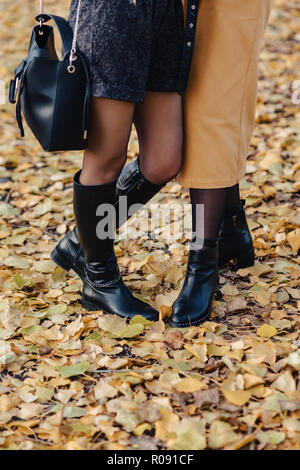 Frau Fuß in shoeses unter gelbe Blätter im Herbst bunte Park Stockfoto