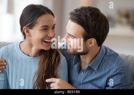 Paar in Liebe reden lachend Sitzen auf der Couch Stockfoto
