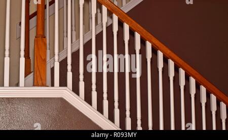 Seitenansicht eines Home Treppe mit Geländer und braun weiß gestrichene Wände mit einem Fokus auf die diagonalen Linien. Stockfoto