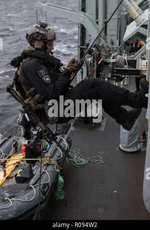 Mitglied Her Majesty's Canadian Ship (Hmcs) VILLE DE QUÉBEC Naval Tactical Operations Team stößt von der Flagge deck während einer Schulung beim Segeln in der Trondheim Fjord, Norwegen während der Übung Trident Zeitpunkt 18. Am 30. Oktober 2018. (Foto von MCpl Andre Maillet) Stockfoto