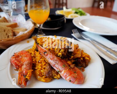 Paella, spanischer Küche, Mallorca Essen, Risotto, Restaurant, leckeres Essen, ein romantisches Abendessen, Brot, Orangensaft, dienen. Stockfoto