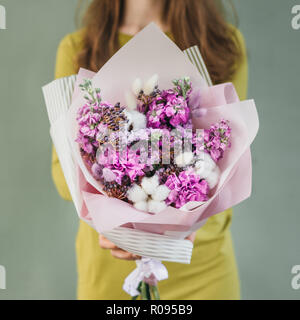 Bunten Strauß von verschiedenen frischen Blumen in der Hand von Floristen Frau. Rustikale Blume Hintergrund. Handwerk Blumenstrauß. Stockfoto