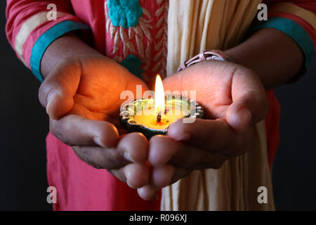 Ein Mädchen, dass isolierte lit Diya zu diwali und dhanteras Feiern Stockfoto