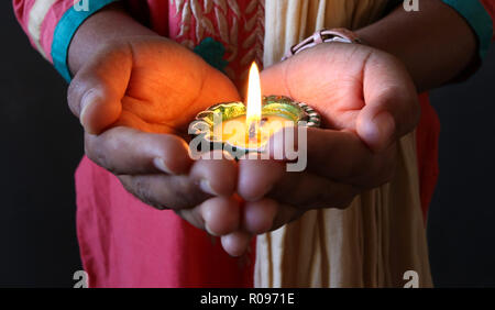 Ein Mädchen, dass isolierte lit Diya zu diwali und dhanteras Feiern Stockfoto