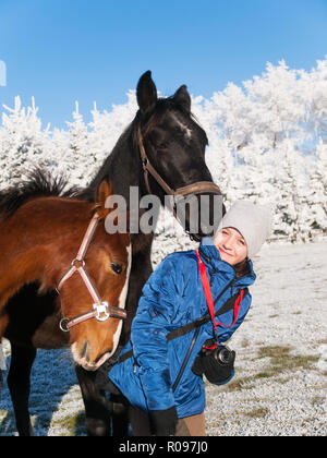 Portrait von Mädchen spielen mit Fohlen auf der Weide im sonnigen Tag Stockfoto